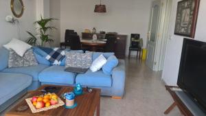 a living room with a blue couch and a table at Casa Triadors in Sant Antoni de Calonge