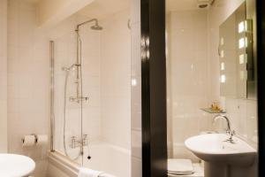 a bathroom with a shower, toilet and sink at Hand & Flower in London