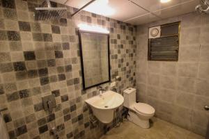 a bathroom with a sink and a toilet and a mirror at Oceans 7 Ashwem in Mandrem