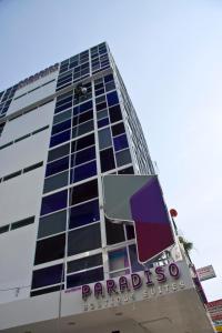 un grand bâtiment avec un panneau devant lui dans l'établissement Paradiso Boutique Suites, à Bangkok