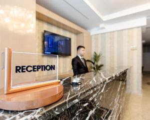 a man in a suit standing behind a reception desk at Mari Suites Hotel in Istanbul
