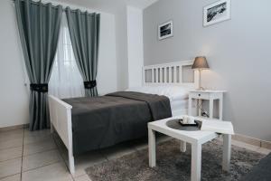 biała sypialnia z łóżkiem i stołem w obiekcie Apartamenty Niezapominajka w Poroninie