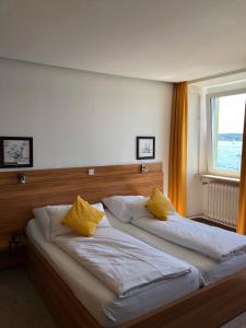 1 dormitorio con 2 camas con almohadas amarillas en Hotel Seegarten en Überlingen