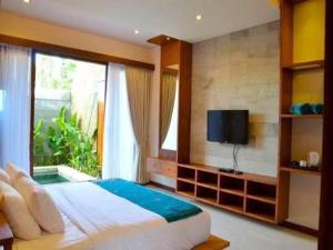 a bedroom with a large bed and a window at Legian Family villa with pool in Legian