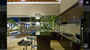 a kitchen with a counter and chairs in a room at Legian Family villa with pool in Legian