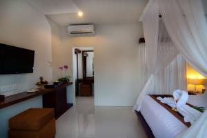 a bedroom with a bed and a television in it at The Awan Villas - CHSE Certified in Seminyak