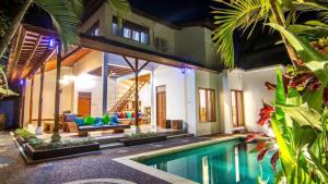 a living room with a swimming pool and a house at Legian Family villa with pool in Legian