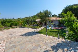 a large patio with a playground and a house at Green Oasis House in Filerimos in Ialysos