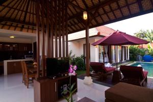 a living room with a television and a pool at The Awan Villas - CHSE Certified in Seminyak