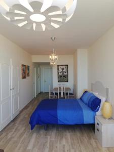 トレモリノスにあるCentral Large Studio Torremolinosのベッドルーム(青いベッド1台、シャンデリア付)
