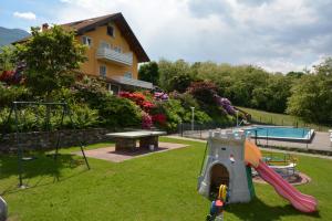 a yard with a playground and a pool and a house at Casa Bellavista 1 in Colico