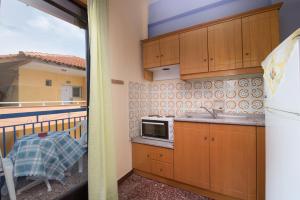 a kitchen with a sink and a microwave on a balcony at House Souzanna in Toroni