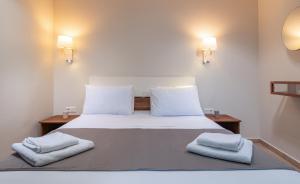 a bedroom with a bed with two towels on it at Kamis Suite in Neos Marmaras