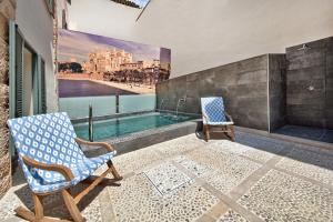 2 Stühle auf einem Balkon mit Pool in der Unterkunft Palma Old Town - Turismo de Interior in Palma de Mallorca