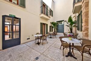 a patio with tables and chairs in a building at Palma Old Town - Turismo de Interior in Palma de Mallorca