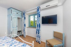 a bedroom with a bed and a window and a chair at Vila Saja in Selce