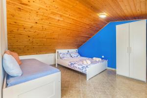 a bedroom with two beds and a blue wall at Vila Saja in Selce