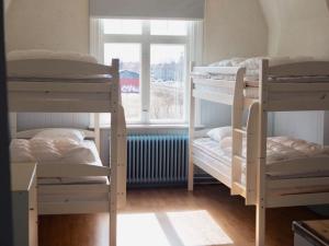 a room with three bunk beds and a window at Orsastuguthyrning-Kyrkbyn in Orsa