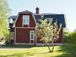 una casa roja con un árbol delante en Orsastuguthyrning-Kyrkbyn en Orsa