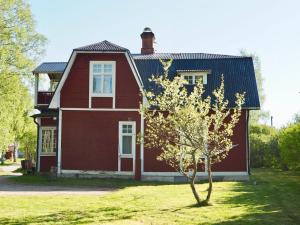 ein rotes Haus mit einem Baum davor in der Unterkunft Orsastuguthyrning-Kyrkbyn in Orsa