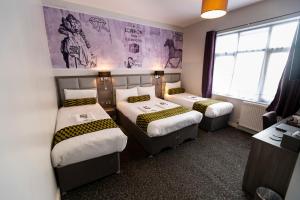 a hotel room with three beds and a window at Comfotel PRPL in London