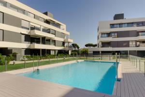 a swimming pool in front of a building at Apartamentos Bahía Blanca in El Puerto de Santa María