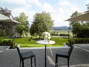 einen Tisch mit zwei Stühlen und eine Vase mit Blumen in der Unterkunft Schloss Neutrauchburg in Isny im Allgäu