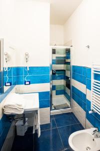 y baño azul y blanco con lavabo y ducha. en Residenza Sole Maiori en Maiori