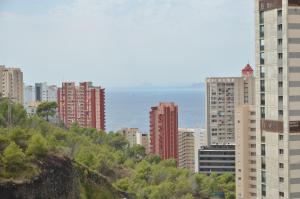 ベニドルムにあるResidencial Cumbre Loix Apartamentosの高層建築物が建ち、海を背景にした都市