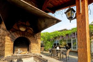 an outdoor patio with a stone fireplace and a table at Dvorik Leva in Truskavets