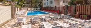 a group of chairs and a pool with a fence at Hotel Topol in Anapa