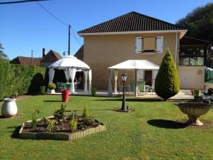 une maison avec deux parasols blancs dans une cour dans l'établissement La Touille, à Cénac-et-Saint-Julien