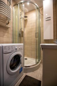 カリシュにあるJDK Apartamenty Podmiejska 38m2 5-osobowyのバスルーム(シャワー付)の洗濯機が備わります。