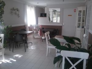 une salle à manger avec des tables et des chaises ainsi qu'une fenêtre dans l'établissement Le Pigeonnier, à Saint-Martin-le-Beau
