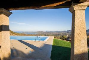 una ventana de una casa con vistas a la piscina en Villa Bouganvillae, en Cugnana