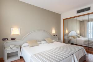1 dormitorio con 1 cama grande y espejo grande en VIK Gran Hotel Costa del Sol en La Cala de Mijas