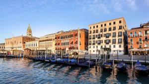 a group of gondolas in the water near buildings at Hotel Danieli, Venice in Venice