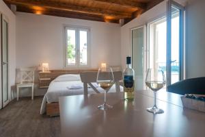 due bicchieri di vino seduti su un tavolo in una camera da letto di Locanda Su Recreu a Cala Gonone