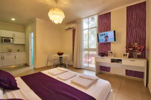 a bedroom with a large bed and a kitchen at 1926 Designed ApartHotel in Haifa