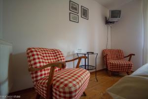 a living room with two chairs and a tv at Penzion Muran in Terchová