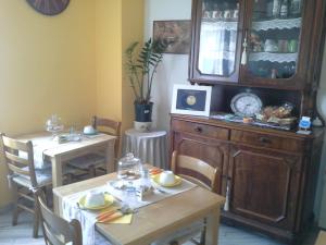 a dining room with two tables and a china cabinet at B&B Ciccilia in Bentivoglio