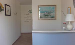 ein Zimmer mit einem Tisch mit einer Lampe und einem Gemälde an der Wand in der Unterkunft B&B Il Giardino di Zefiro in Gioiosa Marea
