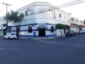 a blue and white building on the corner of a street at Araca Hotel in Araçatuba