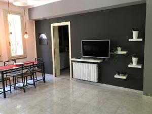 a living room with a table and a television on a wall at Villa Donatella in Parma