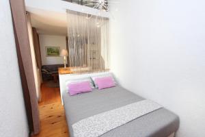 a bedroom with a bed with two pink pillows at Apartment Marjanovic in Rovinj