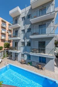 un immeuble d'appartements avec une piscine en face dans l'établissement 7Palms, à Rhodes