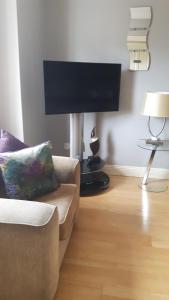 sala de estar con sofá y TV de pantalla plana en Almara House, en Galway