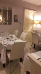 ein Esszimmer mit einem weißen Tisch und Stühlen in der Unterkunft Almara House in Galway