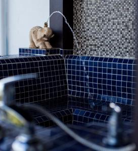 a bathroom with a gargoyle sitting on a blue tile counter at Number 4 in Nai Harn Beach