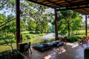 a screened in porch with a view of a river at Reverie Siam in Pai